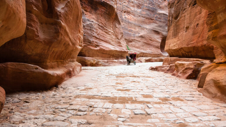 Travel to Middle East country Kingdom of Jordan - stone paved Al Siq passage to ancient Petra city in winter
