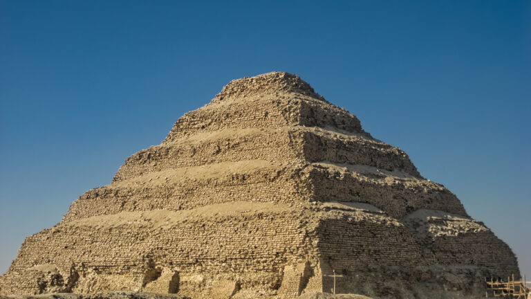 View of the Pyramid of Djoser or Step Pyramid at the necropolis of Saqqara, near Cairo city (Egypt). Front view with blue sky